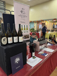Adam derrière un stand lors d'un salon en Savoie